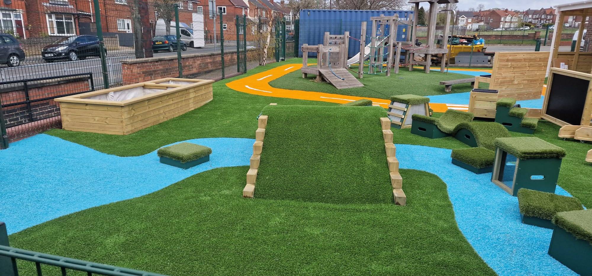 Colourful artificial grass play space with play equipment