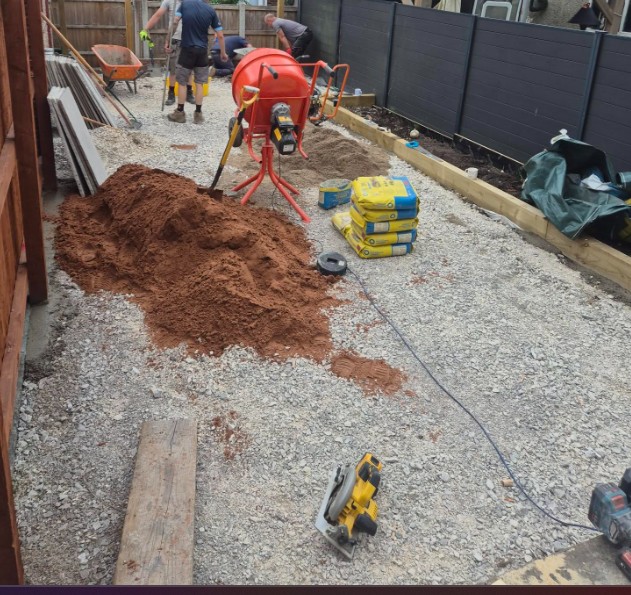 Groundwork in progress in Chadderton, showing the exposed stone base, timber edging and installation equipment